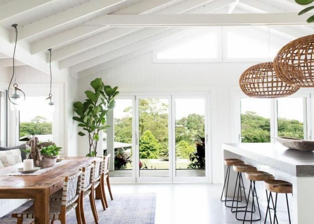 cuisine ouverte salle à manger table tabouret bois poutre blanche suspension osier