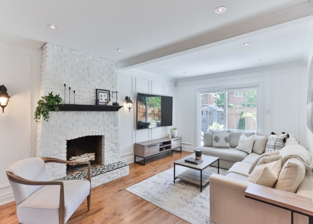 salon lumineux blanc cheminée briques parquet bois