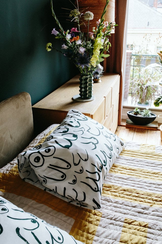 Une chambre verte aux motifs jaune moutarde et blanc rayures
