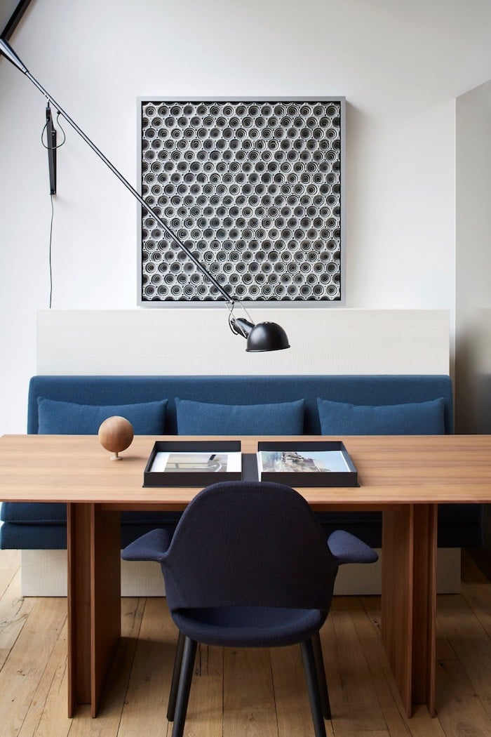 appart parisien toit canape table salle a manger table en bois brut design tableau original noir et blanc assise bleu avec coussin lampe metalique paris appartement