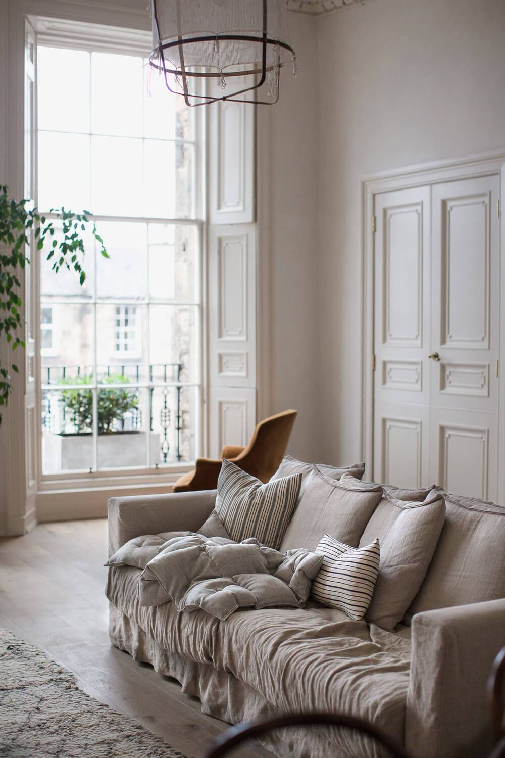 Slow life salon blanc cassé canapé coussin appart parisien clemaroundthecorner