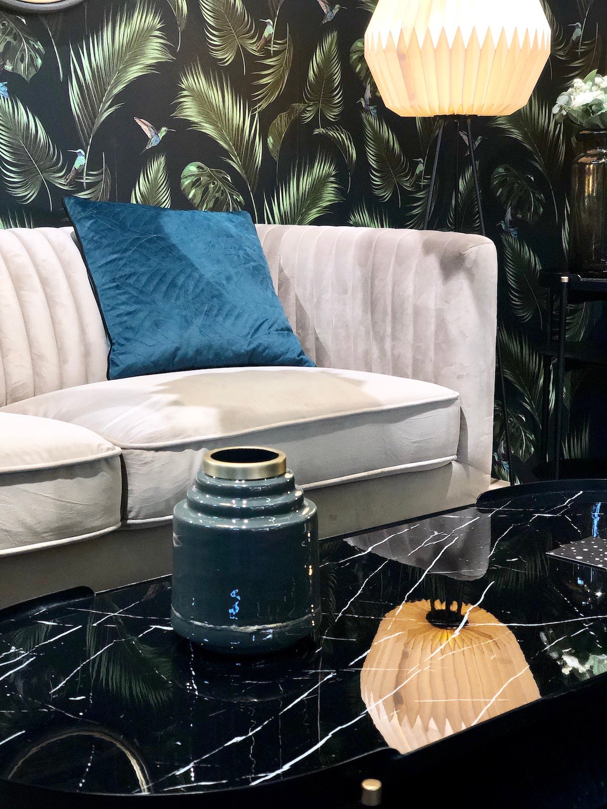 salon foncé mur papier peint noir jungle feuille table marbre ovale noir canapé velours gris années 60 70