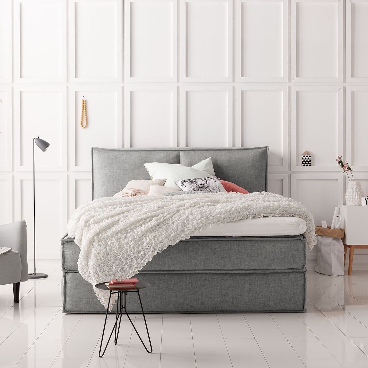 lit double boxspring gris parquet bois blanc moulure mur table basse noir métallique