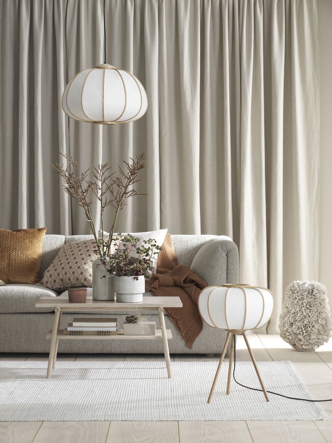 salon élégant canapé gris lampe laiton coussin orange table basse bois
