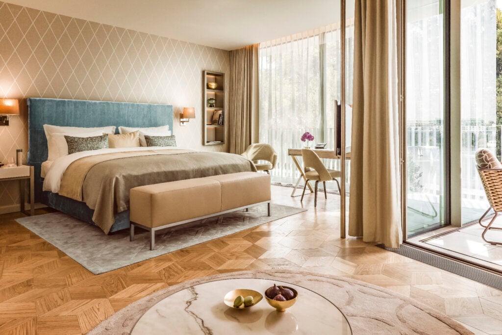 chambre hôtel élégant sobre beige sommier bleu velours parquet bois