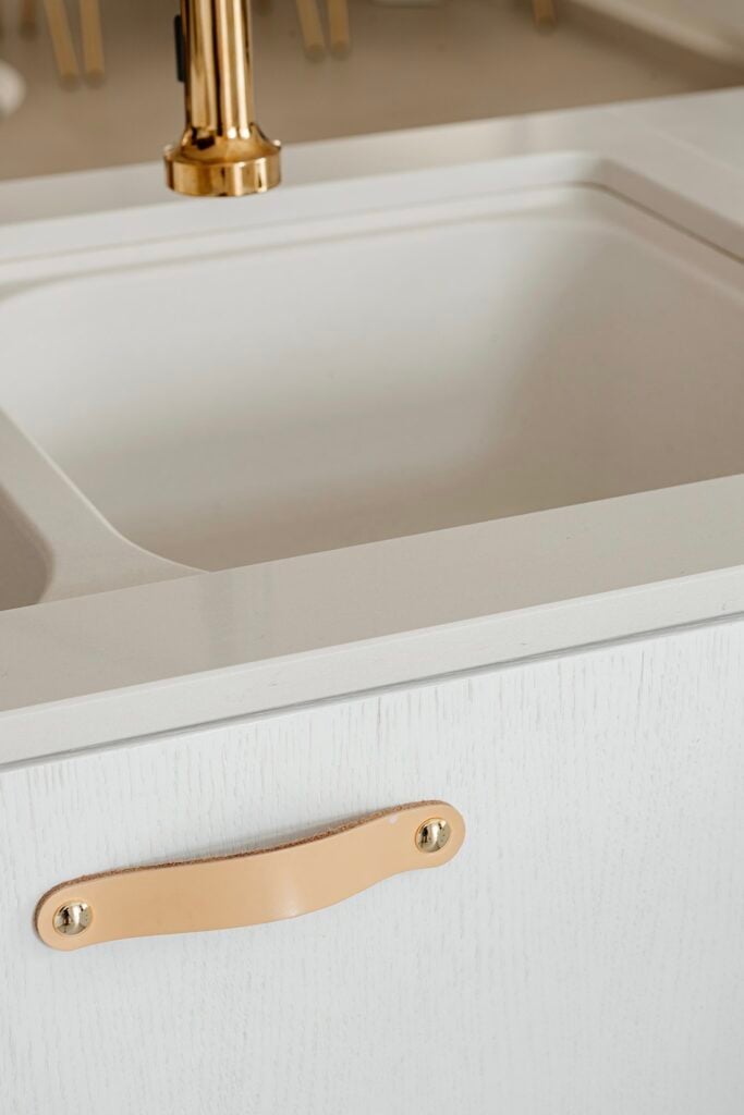 cuisine blanche meuble bois minimaliste poignée cuir naturel beige clair
