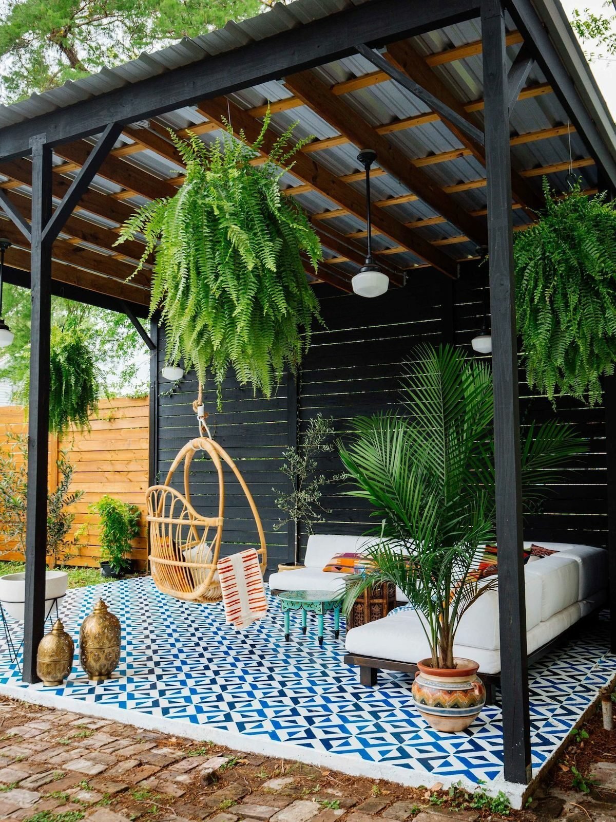terrasse noire pergola sol bleu canapé blanc plantes vertes