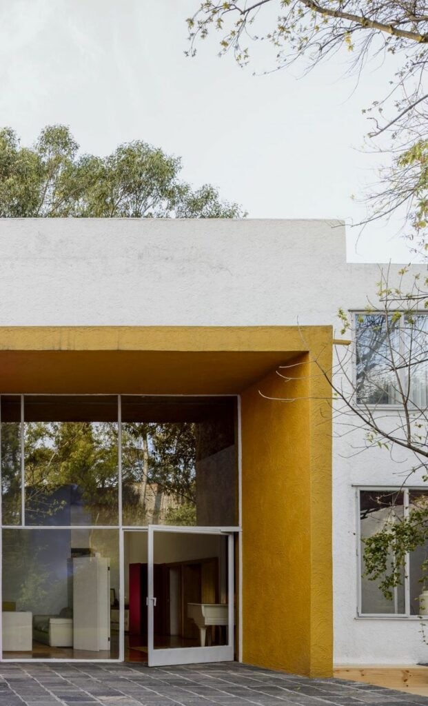 Mur jaune sol pierres plates grises architecture