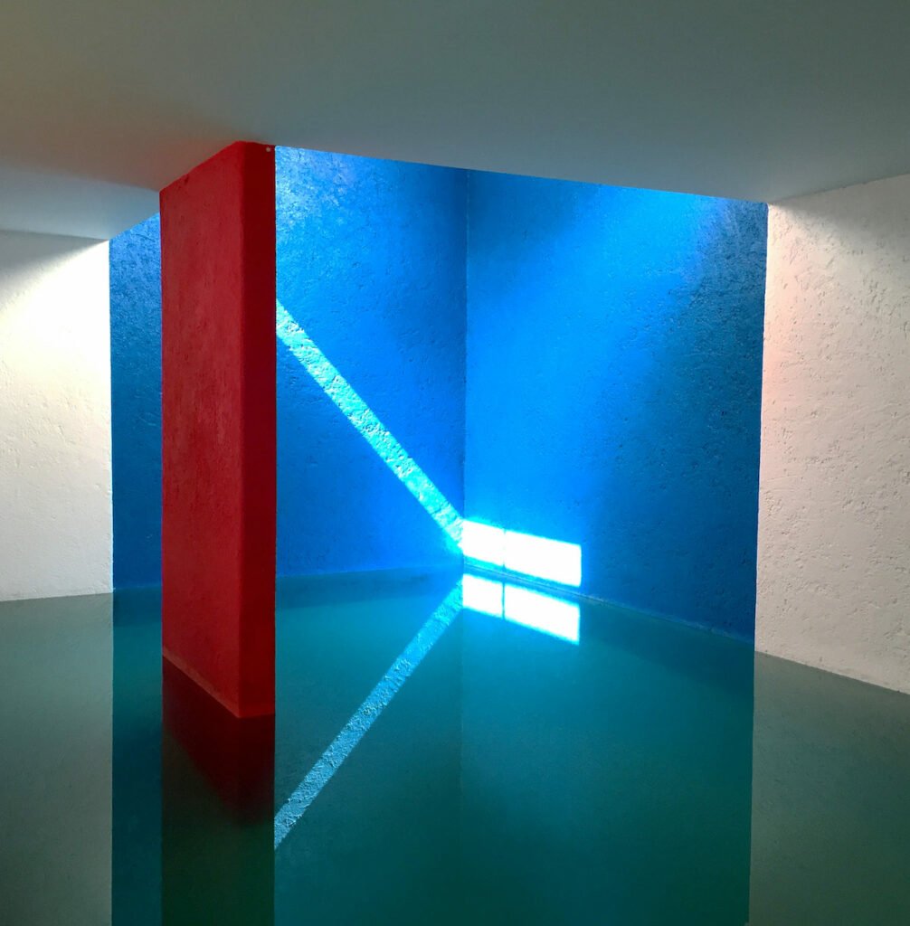 piscine intérieure bleu turquoise rouge magenta mur blanc rayons lumineux